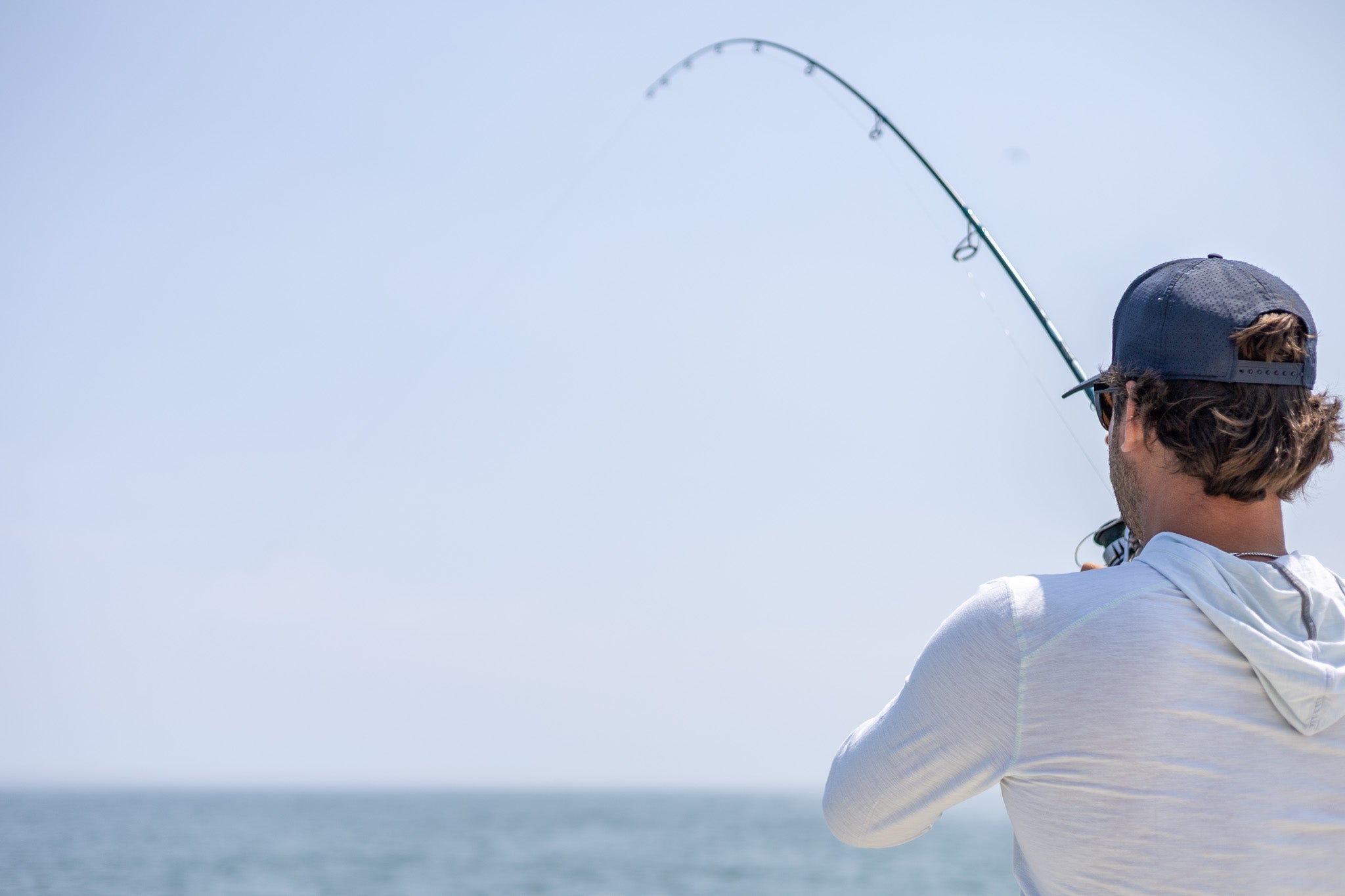 Fisherman with rod bent in the water 